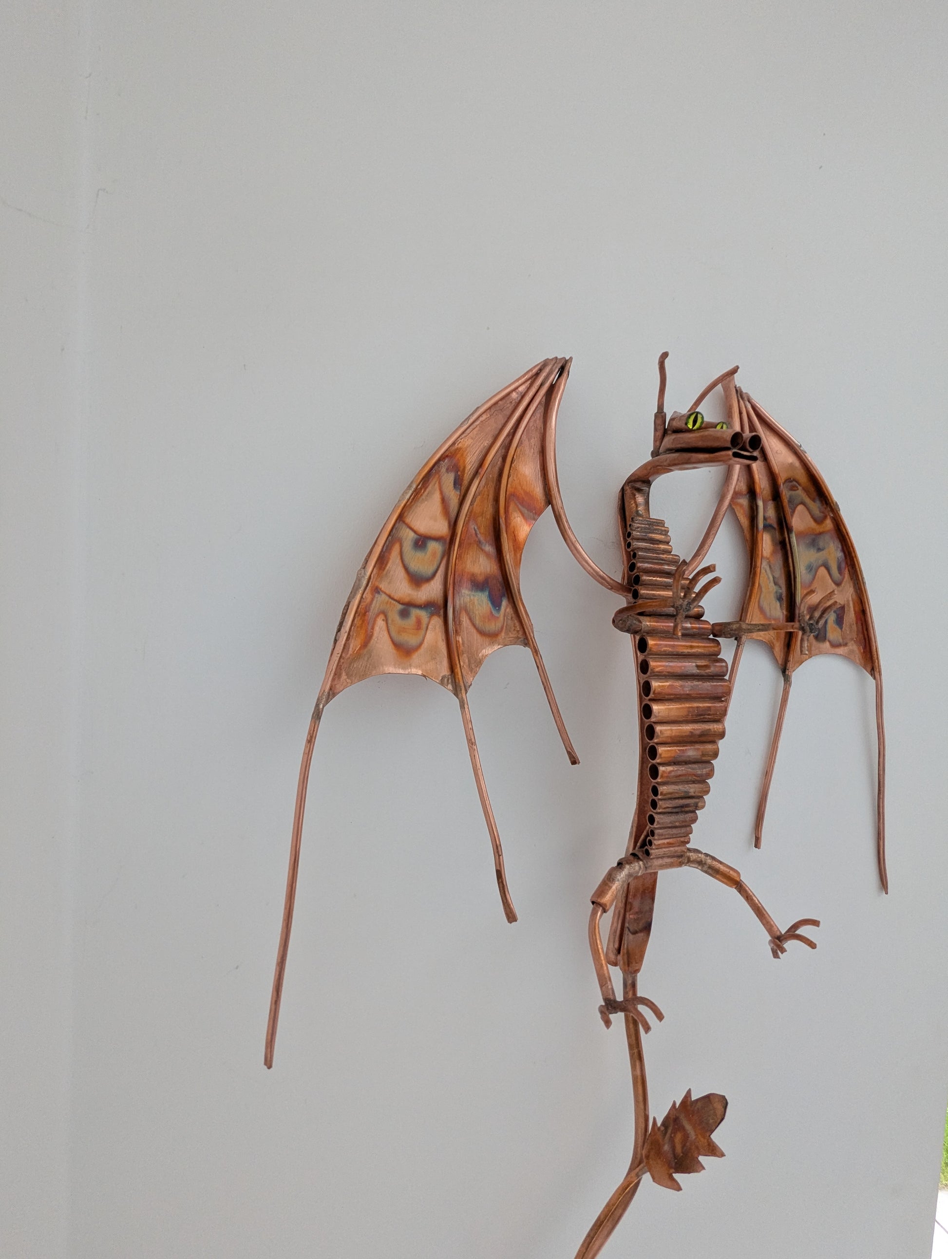 Metal dragon wall art on a plain background